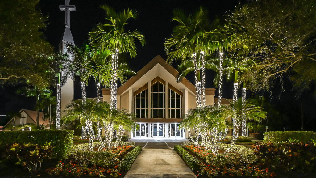 Christmas light installations wrapped around the palm trees on the front walkway of a church in Boca Raton, Florida